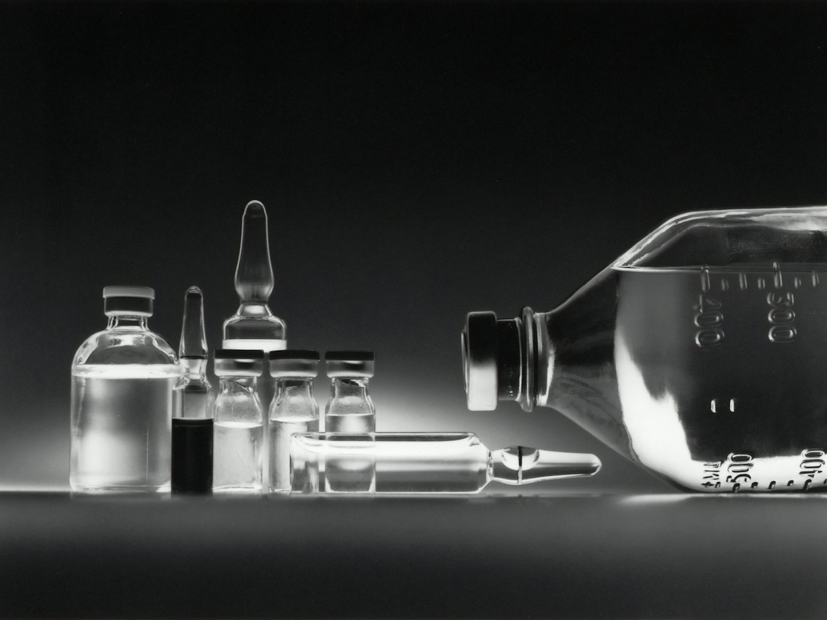 Glass medication vials on a dark surface
